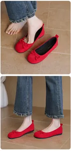 Close-up detail of red suede ballet flats with bow tie and comfortable soft flat sole