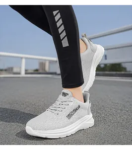 Close-up detail of light grey lightweight athletic running shoes shown on a running track