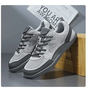 Primer plano de zapatillas deportivas grises de malla transpirable y punta ancha.