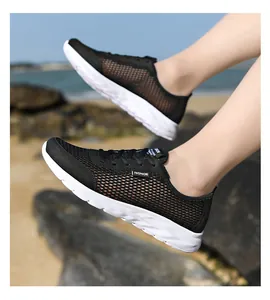 Vue rapprochée des chaussures de sport respirantes en mesh noir pour hommes sur la plage