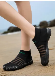 Gros plan de chaussures d'eau en maille respirante sur la plage pour patauger