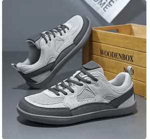 Detalle de zapatillas deportivas de malla gris para hombre con diseño transpirable y duradero.