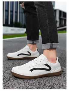 Close-up of white leather casual sneakers with black wave design and gum rubber sole