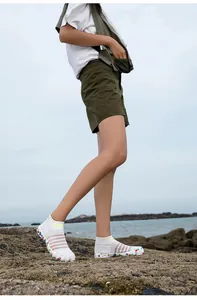 Vue détaillée de chaussures d'eau en maille blanche sur une plage naturelle rocheuse
