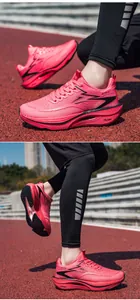 Detailaufnahme der leuchtend rosa Marathon-Laufschuhe mit Carbonplatte auf einer Laufbahn.