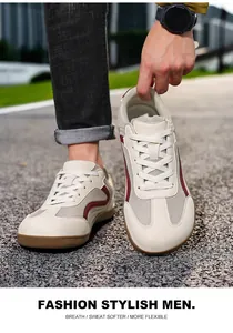 Detail view of breathable wide-toe men's casual trainer shoes on outdoor gravel.