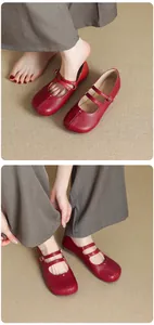 Chaussures Mary Jane plates rouges avec faux bout fendu portées avec un pantalon gris.