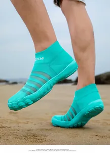 Vue détaillée de chaussures aquatiques en maille respirante turquoise sur la plage