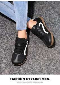 Black men's GAT sneakers with white stripe and brown rubber sole shown on gravel ground