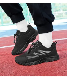 Close-up of black men's breathable athletic walking shoes worn on a red running track surface