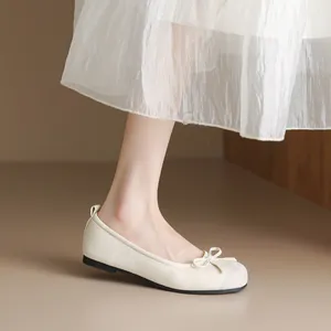 Elegant cream-colored ballet flats featuring bow detail and soft soles for women's daily wear.