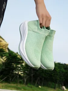 Detailed close-up view of lightweight green breathable knitted slip-on walking shoes