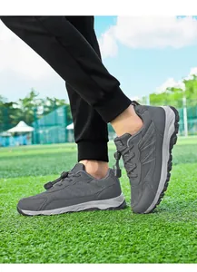 Close-up of grey breathable men's sports walking shoes shown on a green grass background