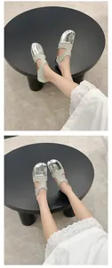Detail view of retro silver split-toe Mary Jane flats on model with white lace skirt.