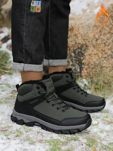 Detail shot of men's olive green hiking boots with plush lining on snow.