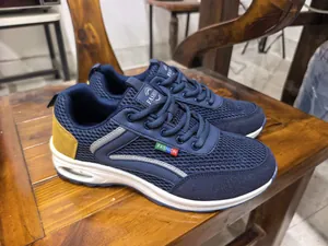 Detailed side view of blue breathable mesh men's sports shoes with white air cushion sole