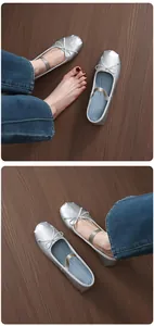 Close-up view of shiny silver Mary Jane ballet flats featuring a bow and elastic strap
