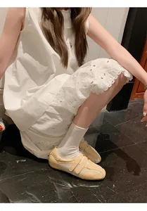 Primo piano di scarpe da ginnastica in rete gialla con velcro e abito di pizzo bianco.