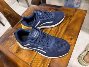 Close-up of navy blue breathable mesh sneakers on wooden surface
