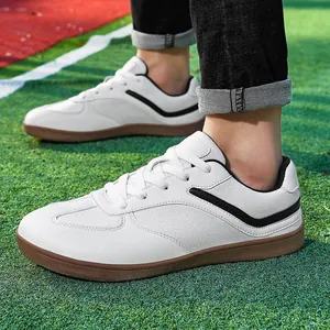 Zapatillas clásicas de cuero blanco estilo trainer con suela de goma en césped verde