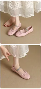 Detailed view of pink Mary Jane ballet flats featuring a bow and silver strap