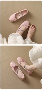 Close-up detail of pink French style bow ballet flats with elastic strap on model's feet