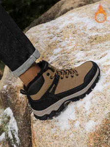 Detail of men's fleece-lined snow boot on a snowy rock for winter hiking adventures