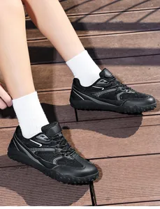 Detalle de zapatillas Samba negras de punta ancha con calcetines blancos