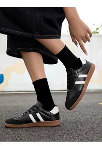 Action shot of black and white German army style sneakers with gum soles and black socks