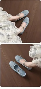 Detailed view of light blue French bow Mary Jane ballet flats on wooden floor