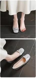 Detailaufnahme silberner Ballerinas mit Glitzerzehe und Schleifendekoration