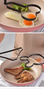 Detail of a funny shaped non-stick egg fryer mold cooking eggs in a pink frying pan