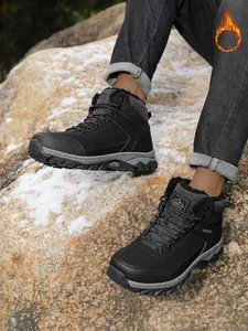 Close-up detail of men's outdoor thermal hiking boots featuring warm faux fur lining on snow