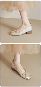 Nahaufnahme der champagnerfarbenen Samt-Ballerinas mit Schleife und Goldkappe