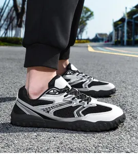 Vista detallada de zapatillas deportivas para hombre en malla blanca y negra sobre asfalto