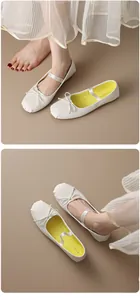 Detailed view of white Mary Jane ballet flats featuring a cute bow and elastic strap