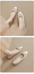 Detailansicht eleganter champagnerfarbener Ballerinas mit Schleife und Karree-Spitze