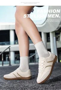 Primo piano di sneakers GAT da uomo in pelle crema con calzini bianchi su sfondo urbano