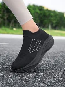 Close-up of black breathable slip-on walking shoes on an outdoor asphalt road