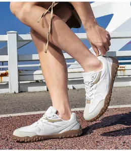Hombre con zapatillas GAT de malla blanca con suelas caqui en un entorno exterior.