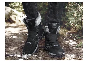 Black winter snow boots with warm faux fur lining shown in an outdoor setting.