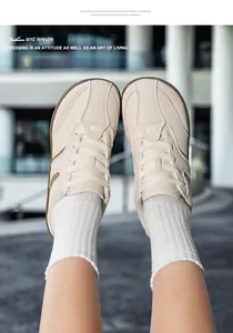 Vista ravvicinata di sneaker casual in pelle bianco sporco con posa creativa a calcio.