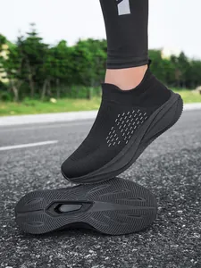 Detail view showing the slip-on design and anti-slip sole pattern of black walking shoes.
