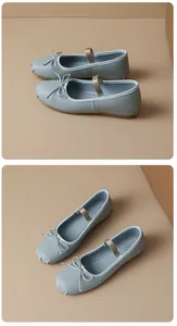 Close-up detail view of elegant light blue Mary Jane ballet flats with bow and elastic strap