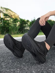 Close-up detail of lightweight black breathable slip-on sneakers with textured non-slip soles