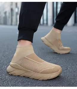 Khaki fly-knit high-top sock sneakers worn on a street for casual athletic style