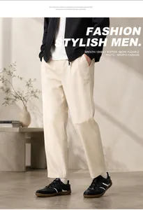 Vista dettagliata delle sneakers in pelle nera da uomo con pantaloni beige casual.