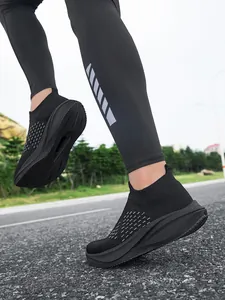 Close-up of black breathable slip-on walking shoes for men and women on asphalt road.