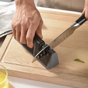 Professional handheld two-stage knife sharpener tool being used on a wooden cutting board