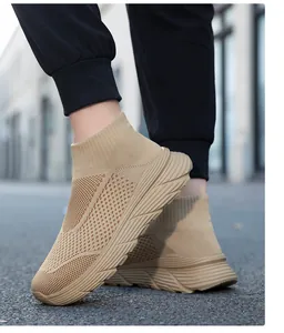 Detail view of khaki high-top fly-knit sock sneakers worn in an urban street setting.